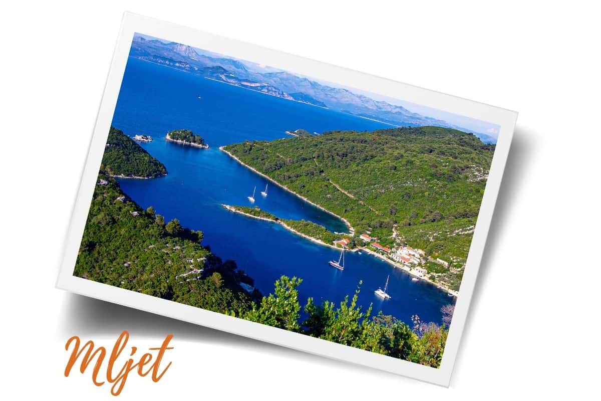 Aerial view of Mljet National Park's pristine saltwater lakes surrounded by dense Mediterranean forest with sailing boats anchored in turquoise waters, top day trip destination from Dubrovnik, Croatia.
