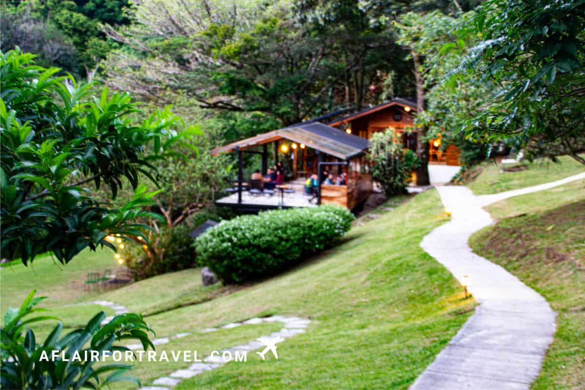 Cervecería Belmar restaurant in Monteverde, Costa Rica, featuring rustic wooden structure nestled in lush tropical forest with winding garden pathway.