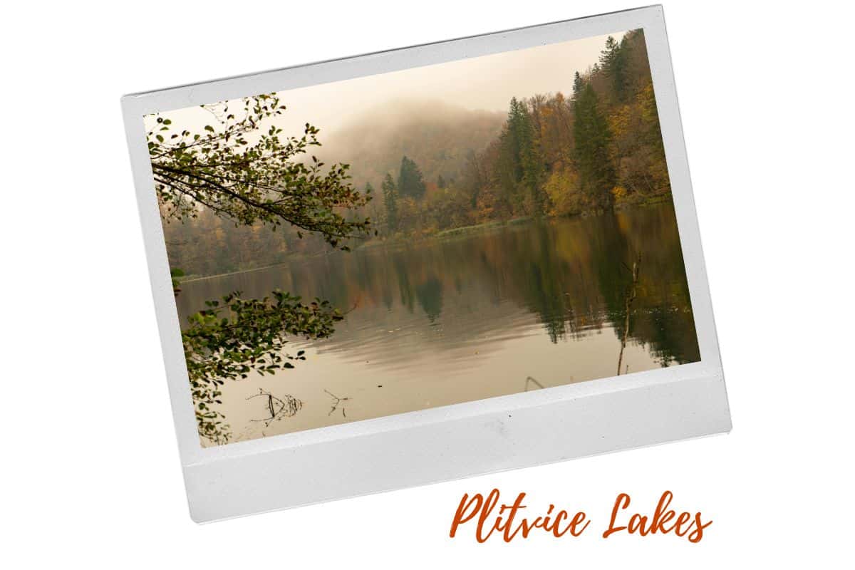 Plitvice Lakes National Park during autumn with trees in shades of gold, red and yellow. There's a mist covering the mountain in the background. Fall is one of the best times to visit Croatia.