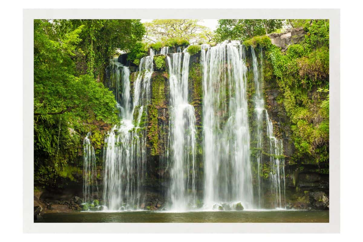 Wide waterfall cascading into pool surrounded by rainforest, showcasing the best time to visit Costa Rica during green season