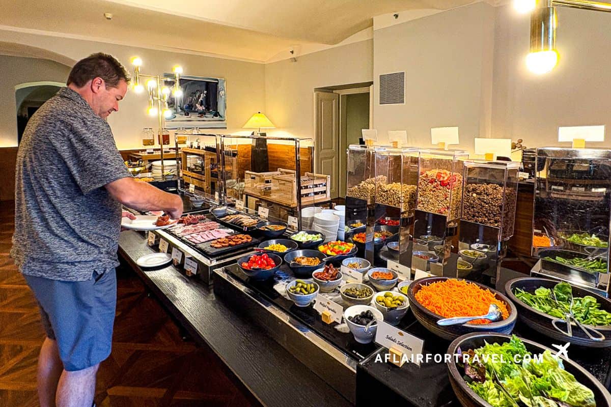Extensive breakfast buffet spread at Mandarin Oriental Prague with hot items, fresh vegetables, cereals, and guest selecting food