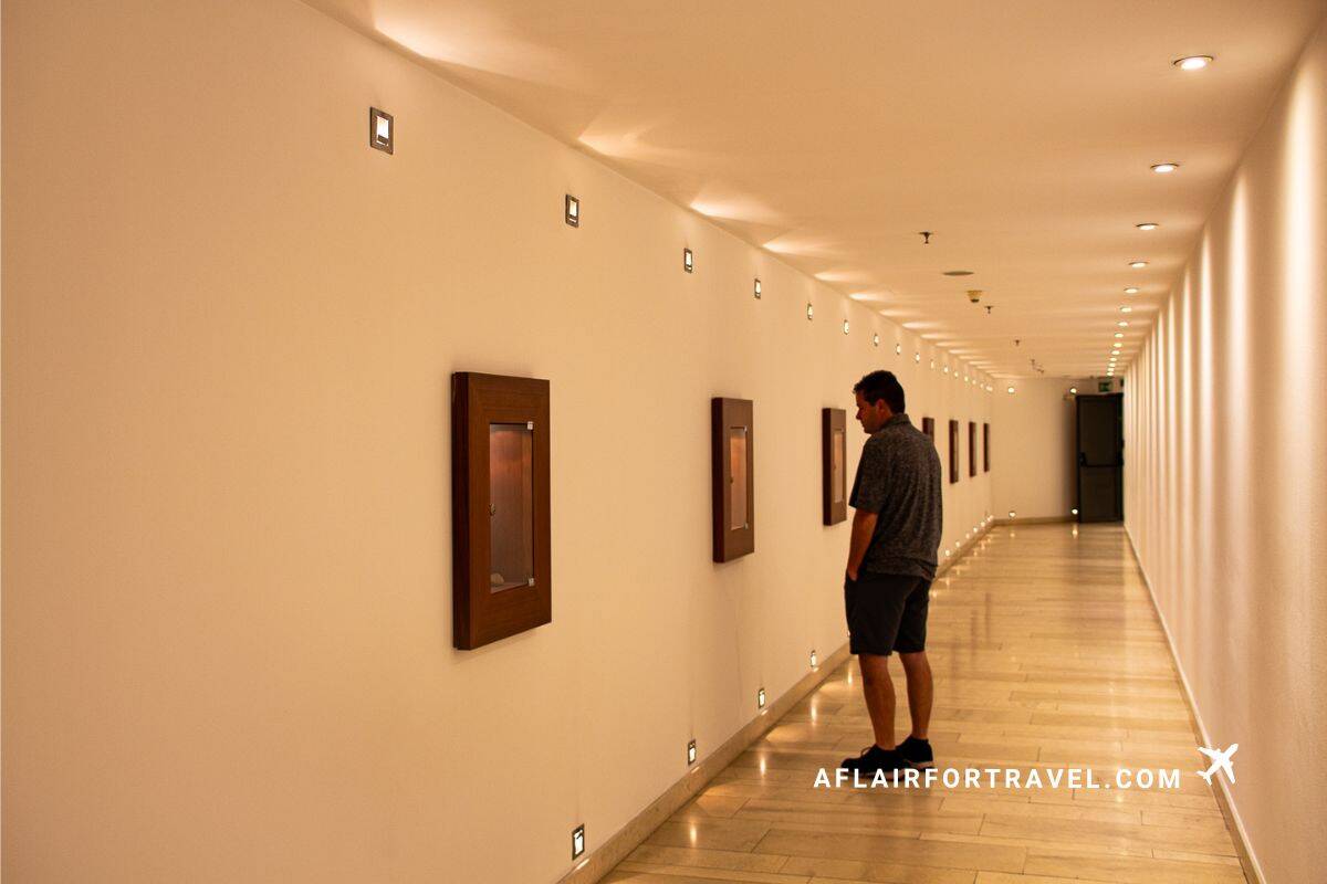 Modern hotel hallway with warm lighting, polished floors, and framed artwork at Mandarin Oriental Prague