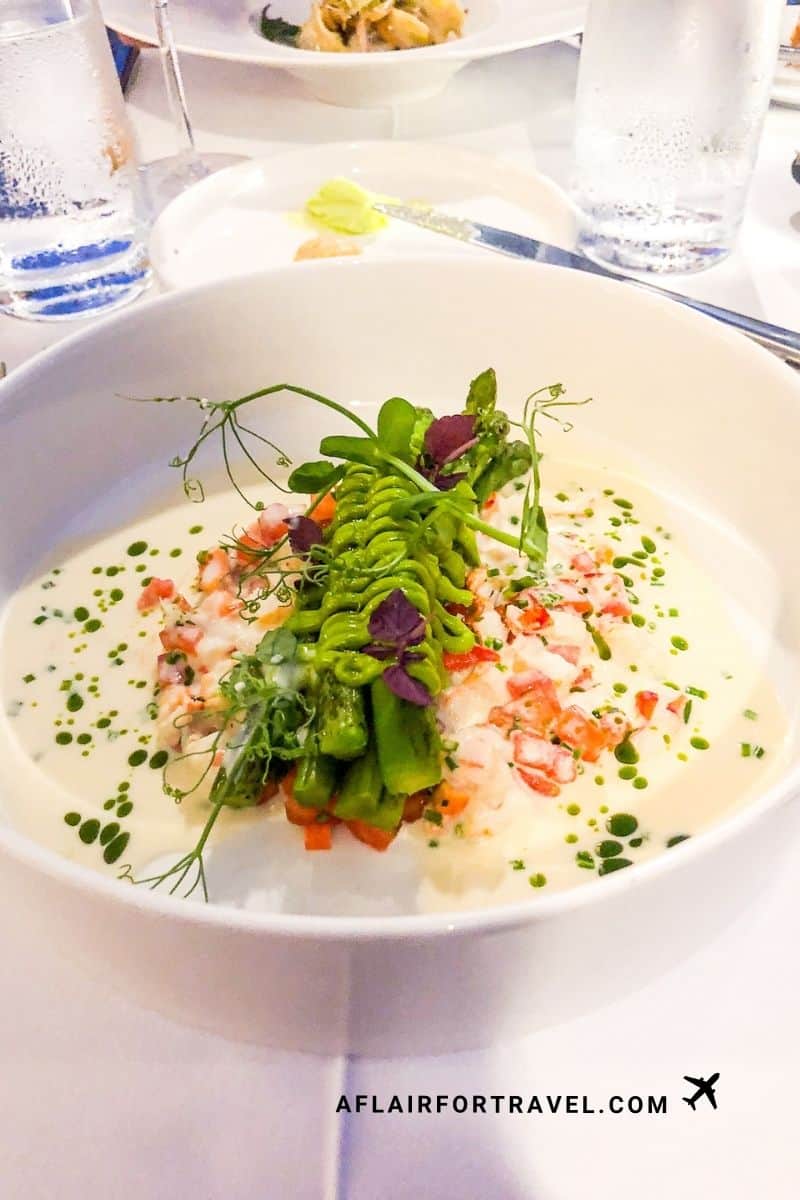 Artfully plated seafood dish at Above 5 with vegetables and microgreens with herb oil dots
