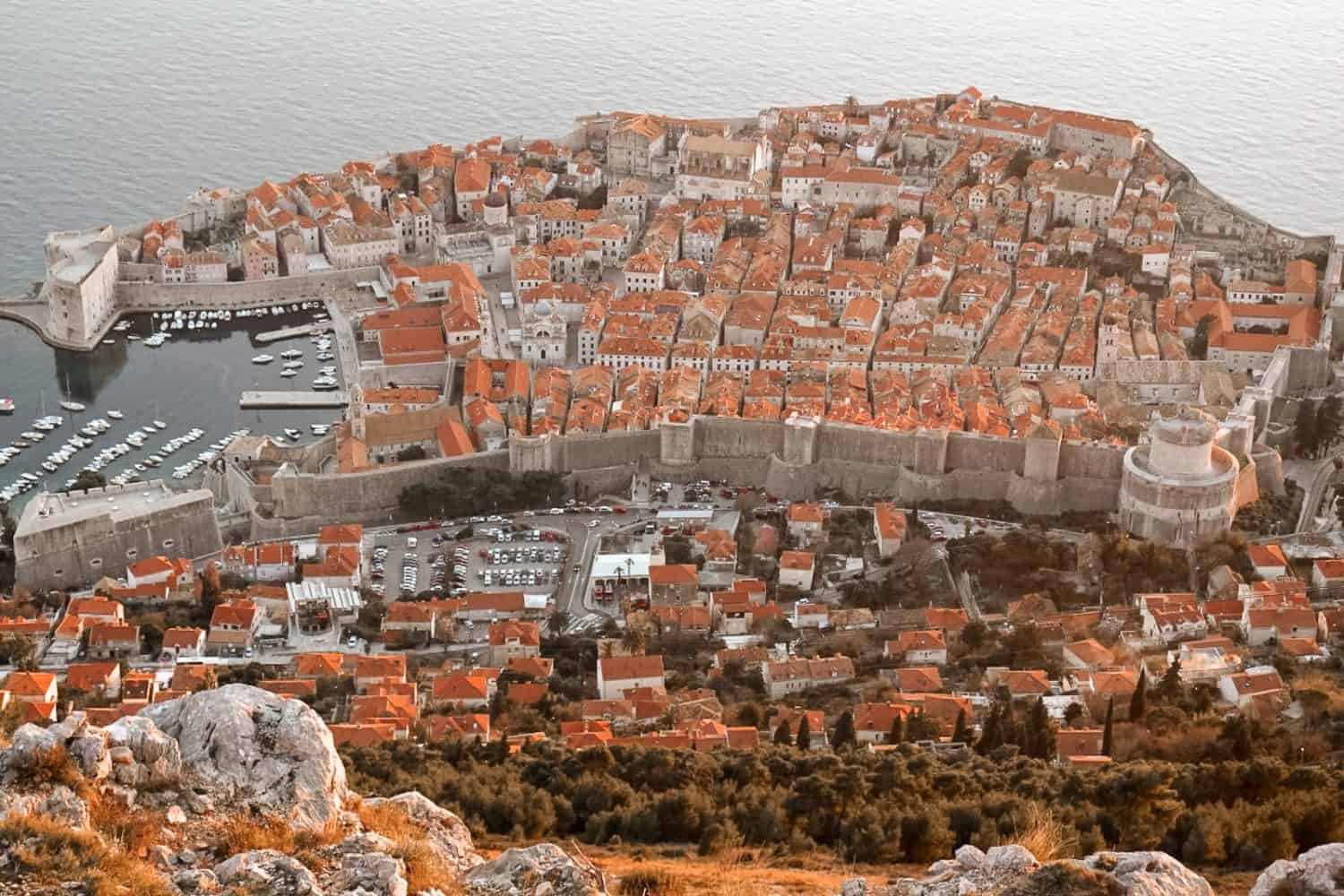 Aerial view of Dubrovnik old town from Mount Srđ, Panorama Restaurant and Bar vantage point overlooking terracotta rooftops, city walls, and Adriatic Sea