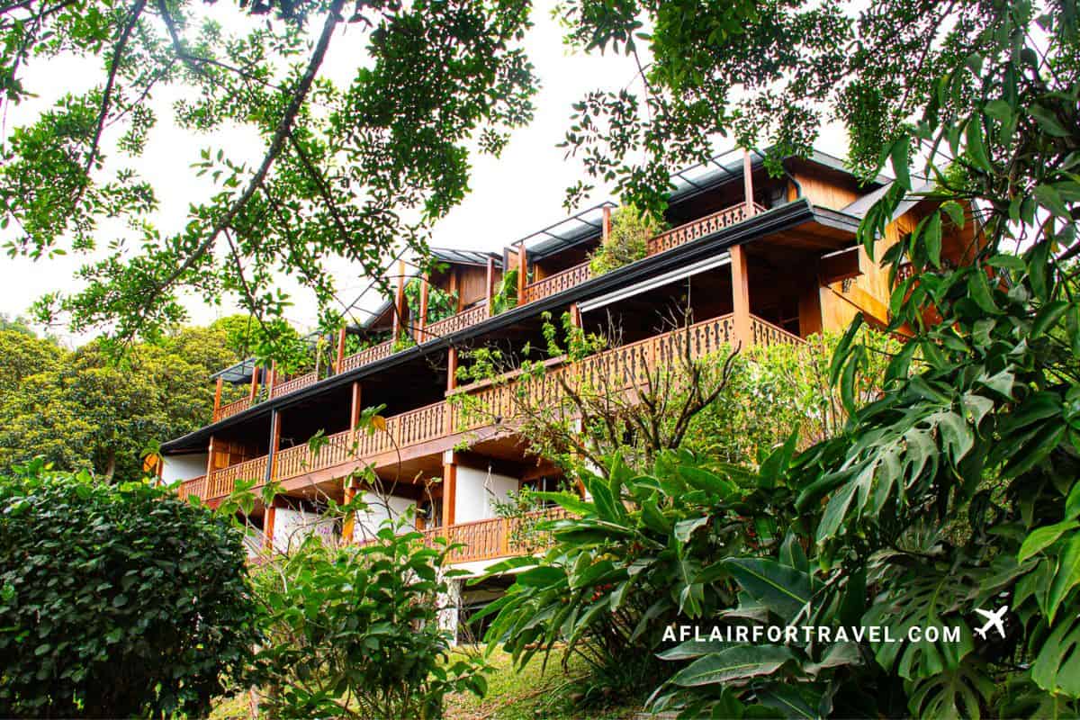 Multi-story wooden balconies on each level at Hotel Belmar built into hillside surrounded by dense tropical vegetation in Monteverde, Costa Rica cloud forest