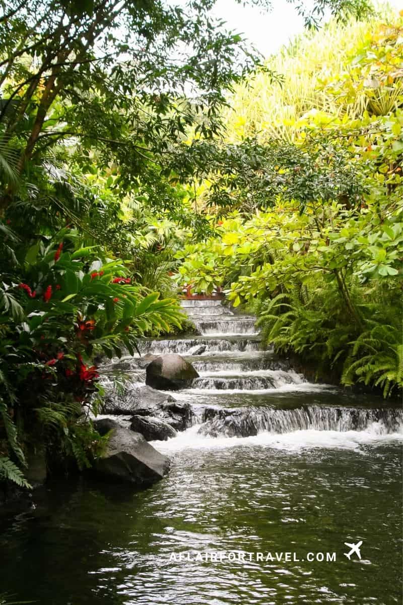 Tabacón Resort hot spring pools cascade through lush tropical gardens near in Costa Rica