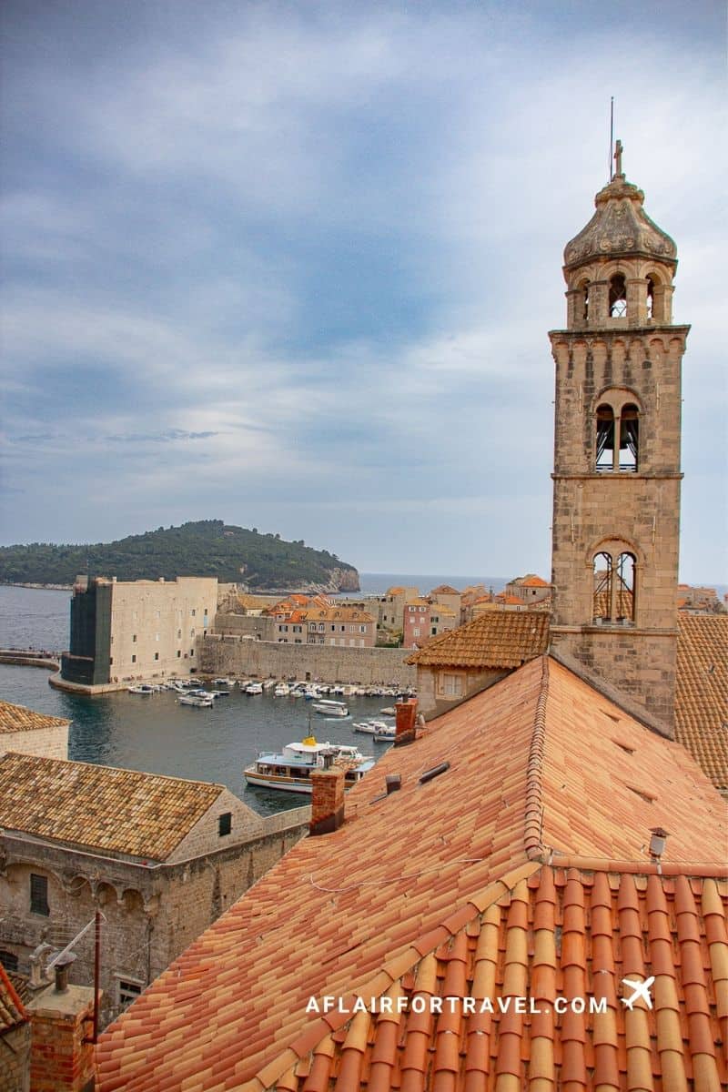 Harbor view and fortress seen from Dubrovnik city walls with bell tower in foreground