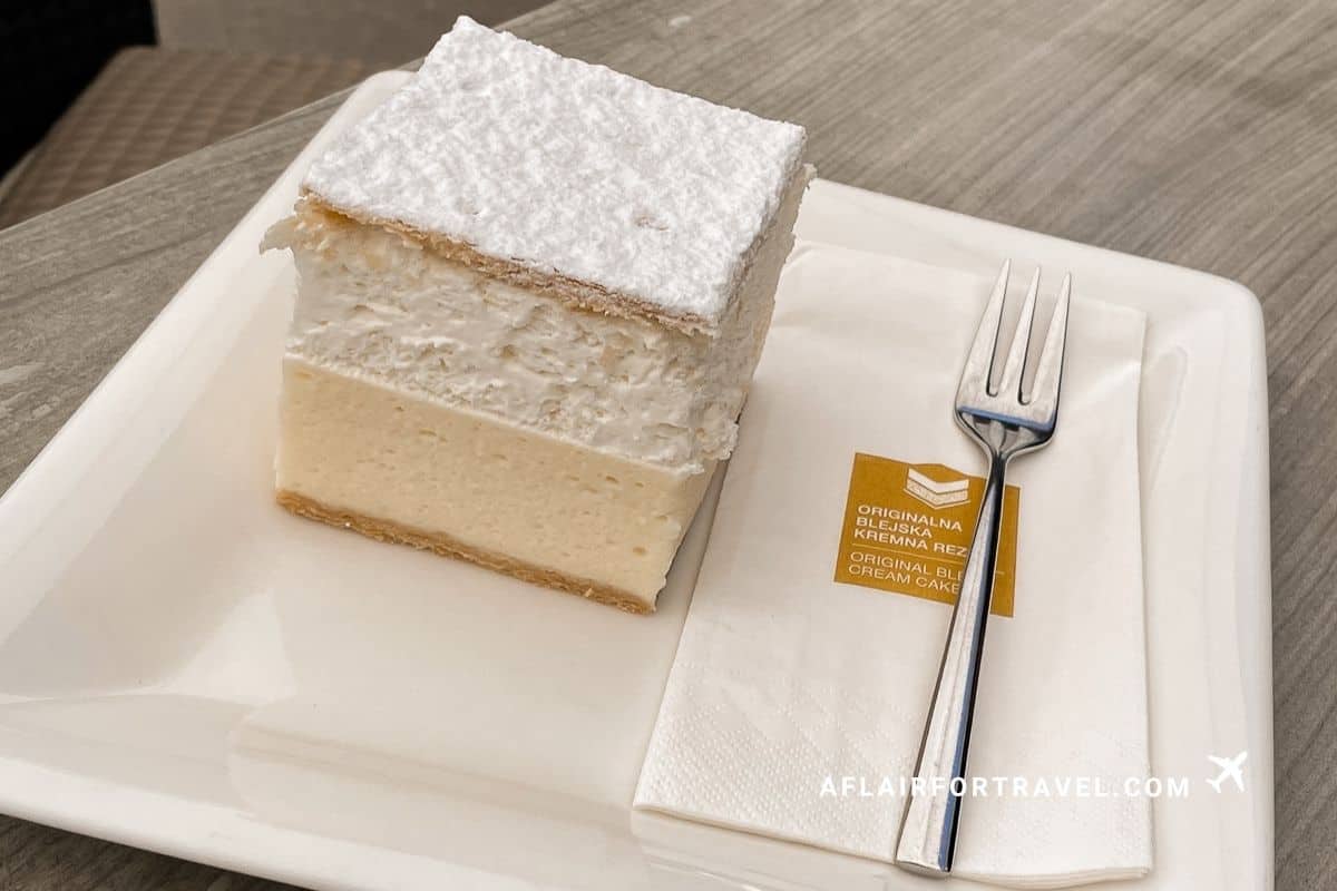 Classic Bled cream cake topped with powdered sugar served on a white plate in Slovenia