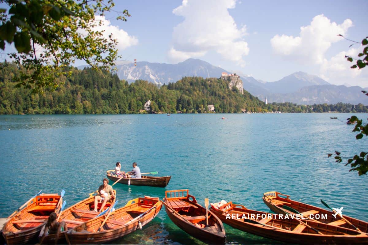 Wooden boats on Lake Bled with Bled Castle and mountains in the background