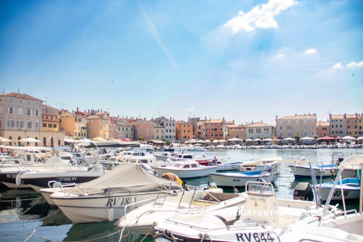 Boats docked along the colorful waterfront harbor in Rovinj, Croatia on a sunny afternoon just steps from the Adriatic Hotel, one of many boutique hotels in Croatia.