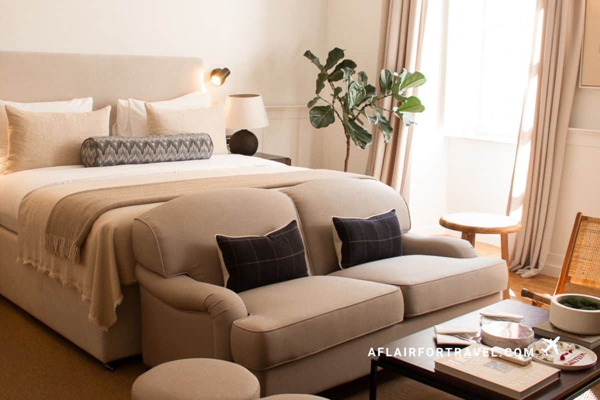 Stylish hotel room interior in Croatia with warm neutral decor, king bed and cozy seating area