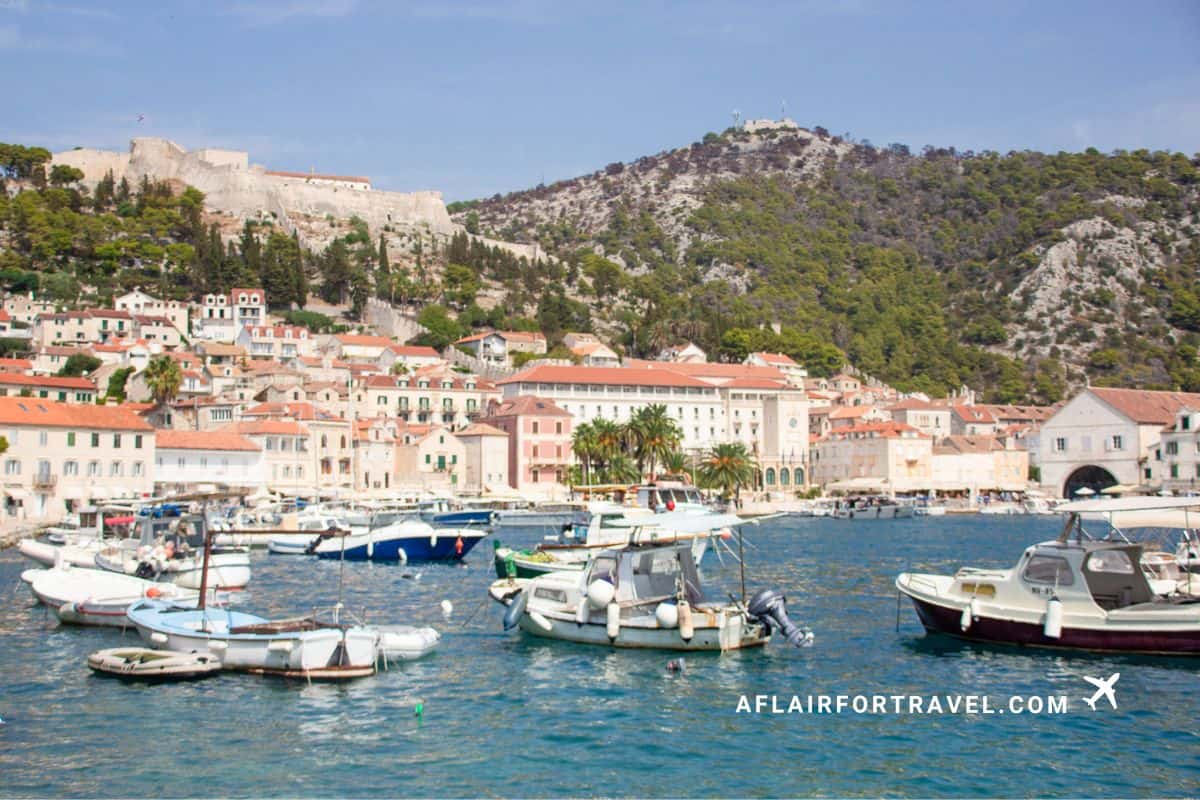 Boats moored in Hvar Town harbour with the hilltop fortress and terracotta rooftops in the background, one of Croatia's most visited island destinations