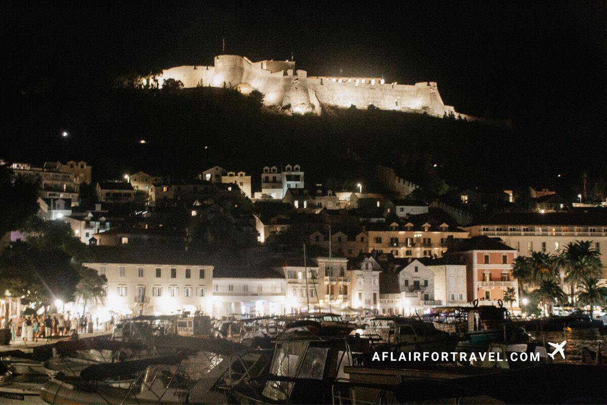 Hvar Town illuminated at night with its hilltop fortress glowing above the busy harbour; it's easy to forget that people do live here, a reminder to keep noise levels down in residential areas, a reminder of what not to do in Croatia