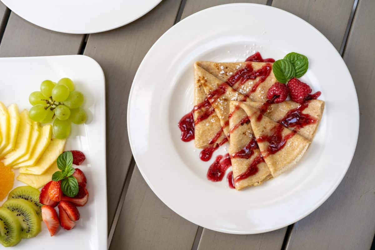 Crepes with raspberry sauce and fresh fruit served on the outdoor terrace at Heritage Hotel Antique Split, one of the best boutique hotels in Croatia.