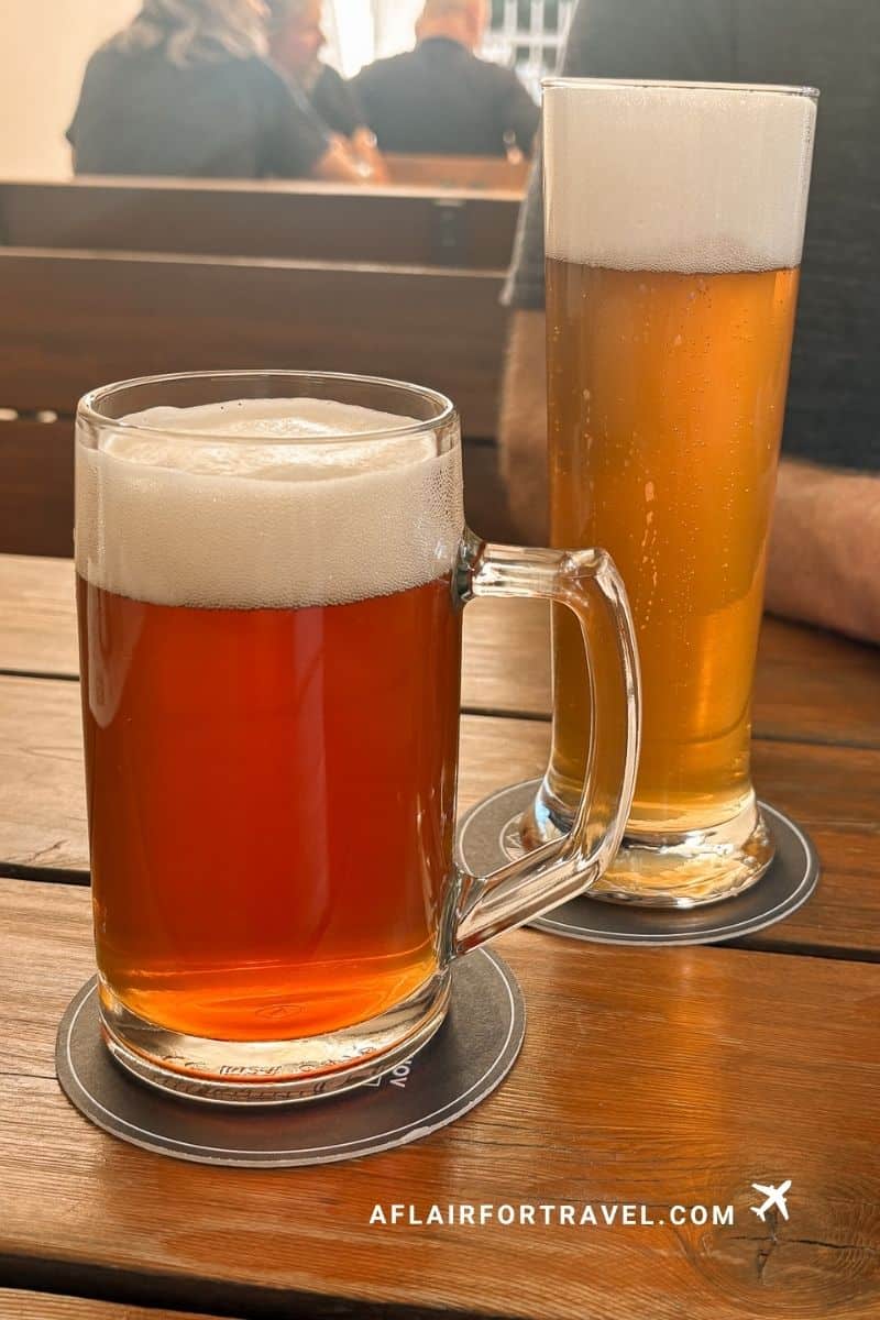 Two glasses of Czech beer served on a wooden table at Strahov Monastery.