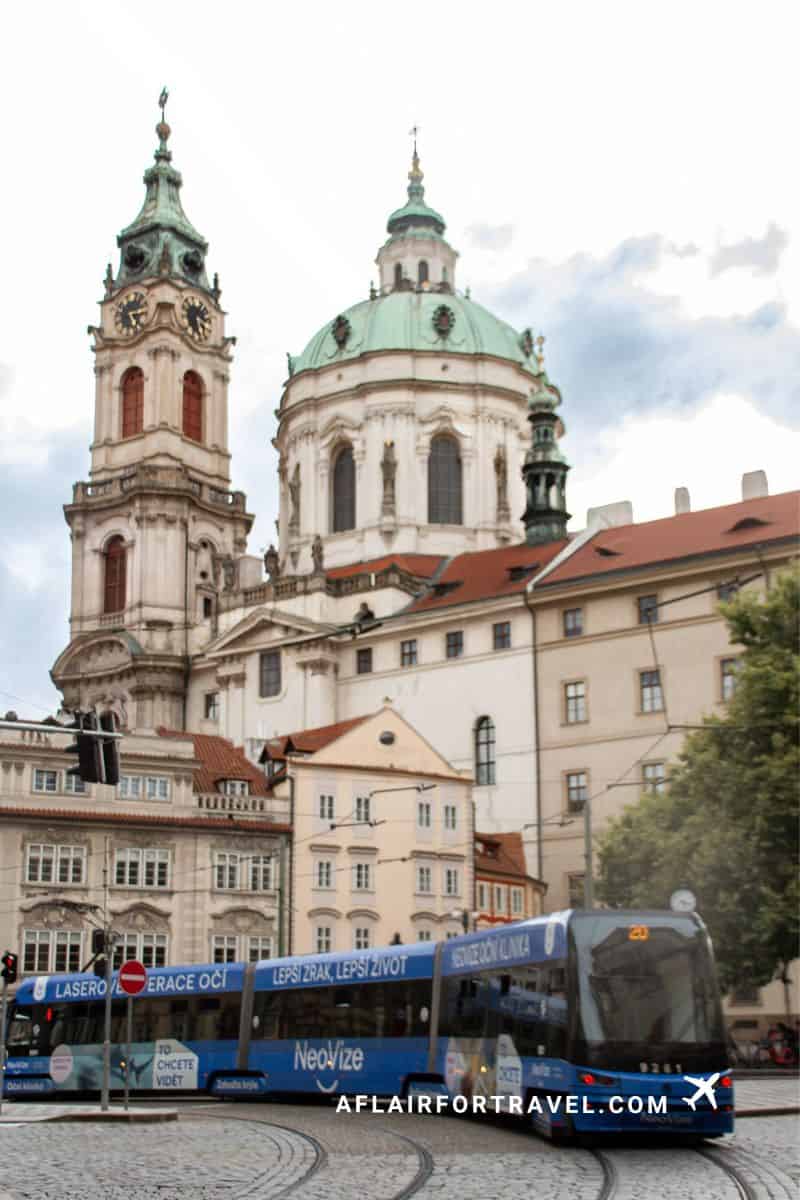 St. Nicholas Church towers above a passing tram in Malostranské náměstí