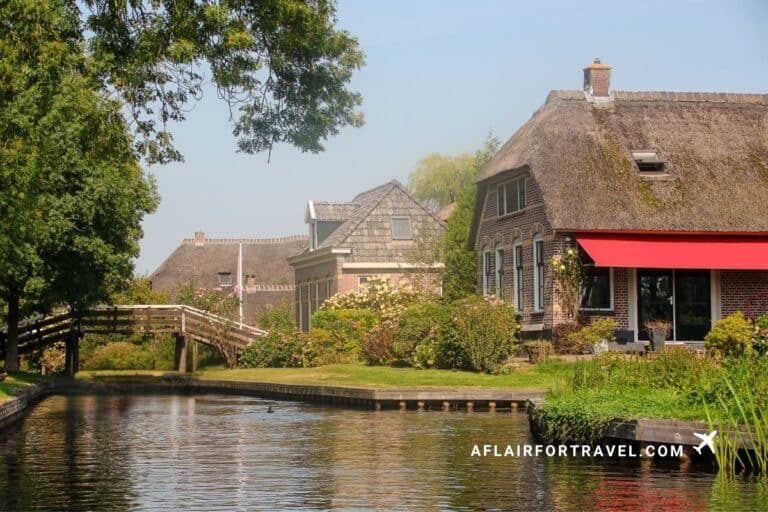 Traditional thatched-roof homes along a peaceful canal in the Dutch village of Giethoorn, Netherlands.