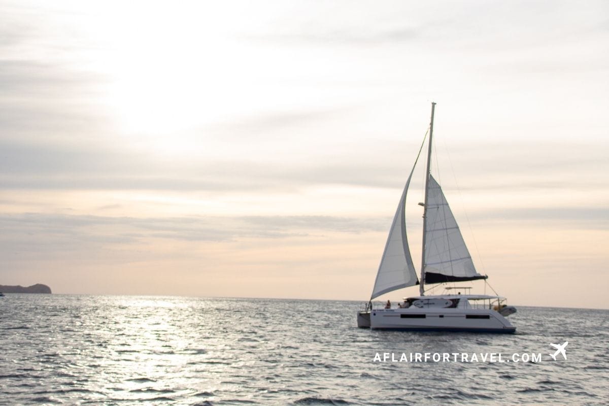 A sailboat catamaran on the water at sunset off the coast of Costa Rica