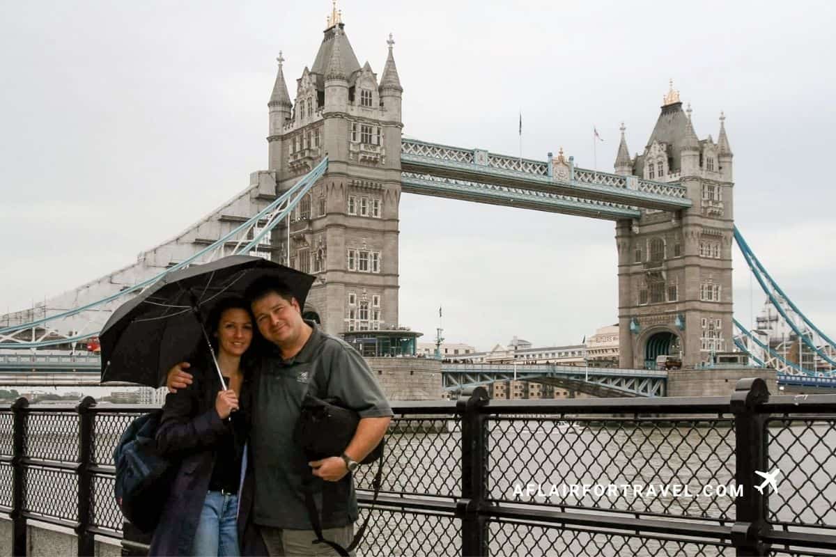 Couple sharing an umbrella in front of Tower Bridge in London, a classic stop on a first-time trip to Europe