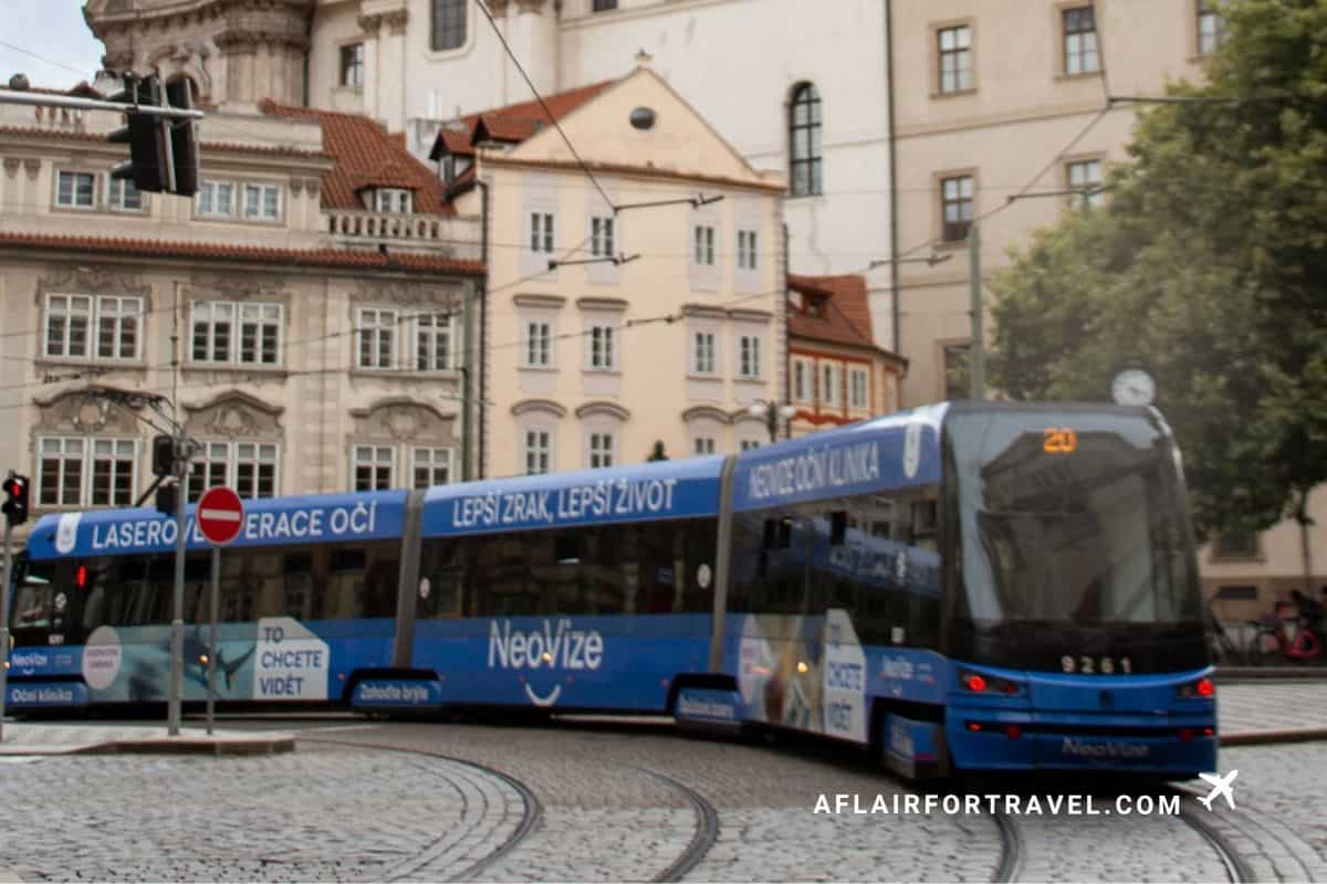 Modern tram passing historic buildings in Malá Strana, Prague