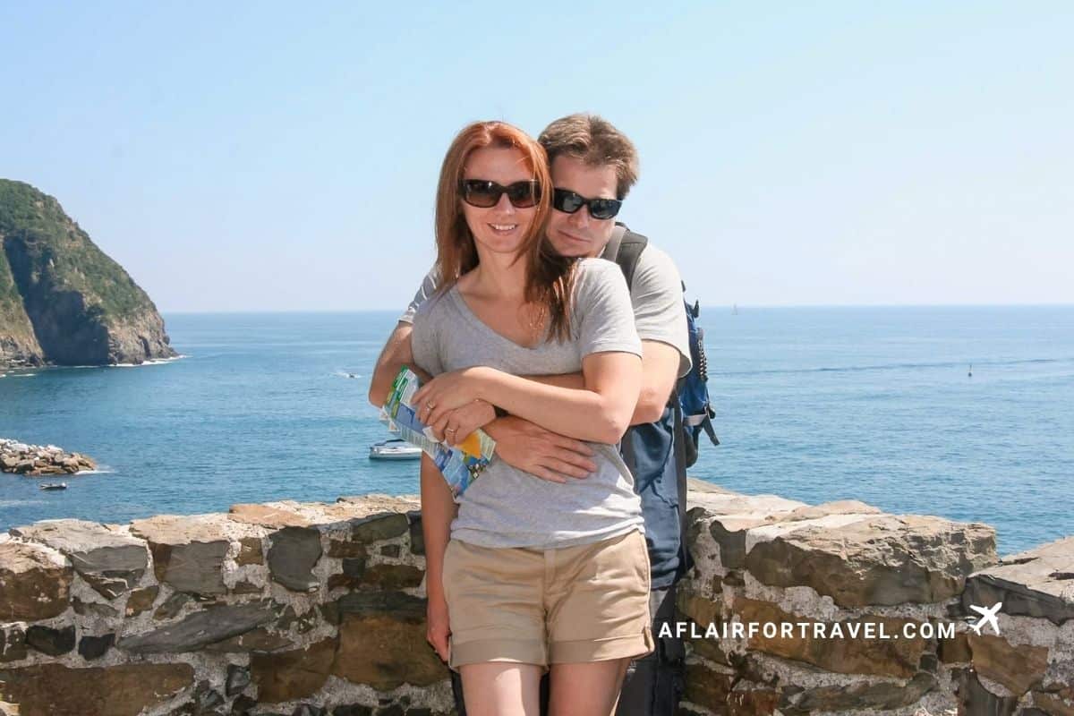 Couple posing above the sea in Cinque Terre, Italy, a memorable stop on a first-time trip to Europe