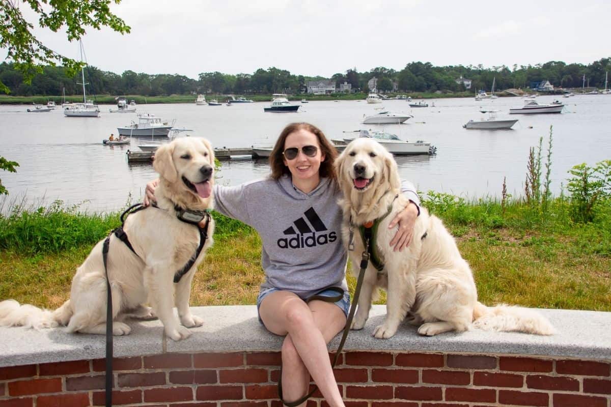 Woman posing with two golden retrievers at a dog-friendly spot in Newburyport MA
