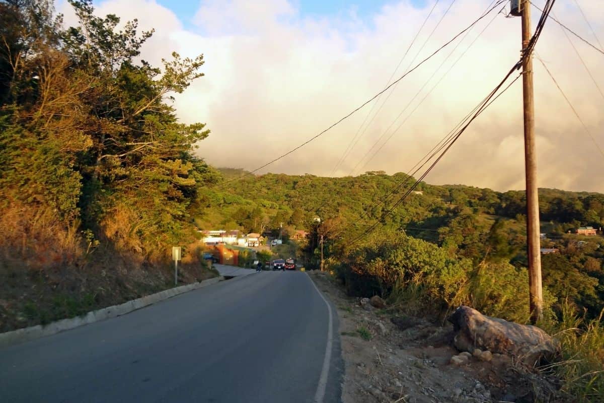 A quiet paved road at dusk winding through the hills, part of the everyday driving experience in Costa Rica