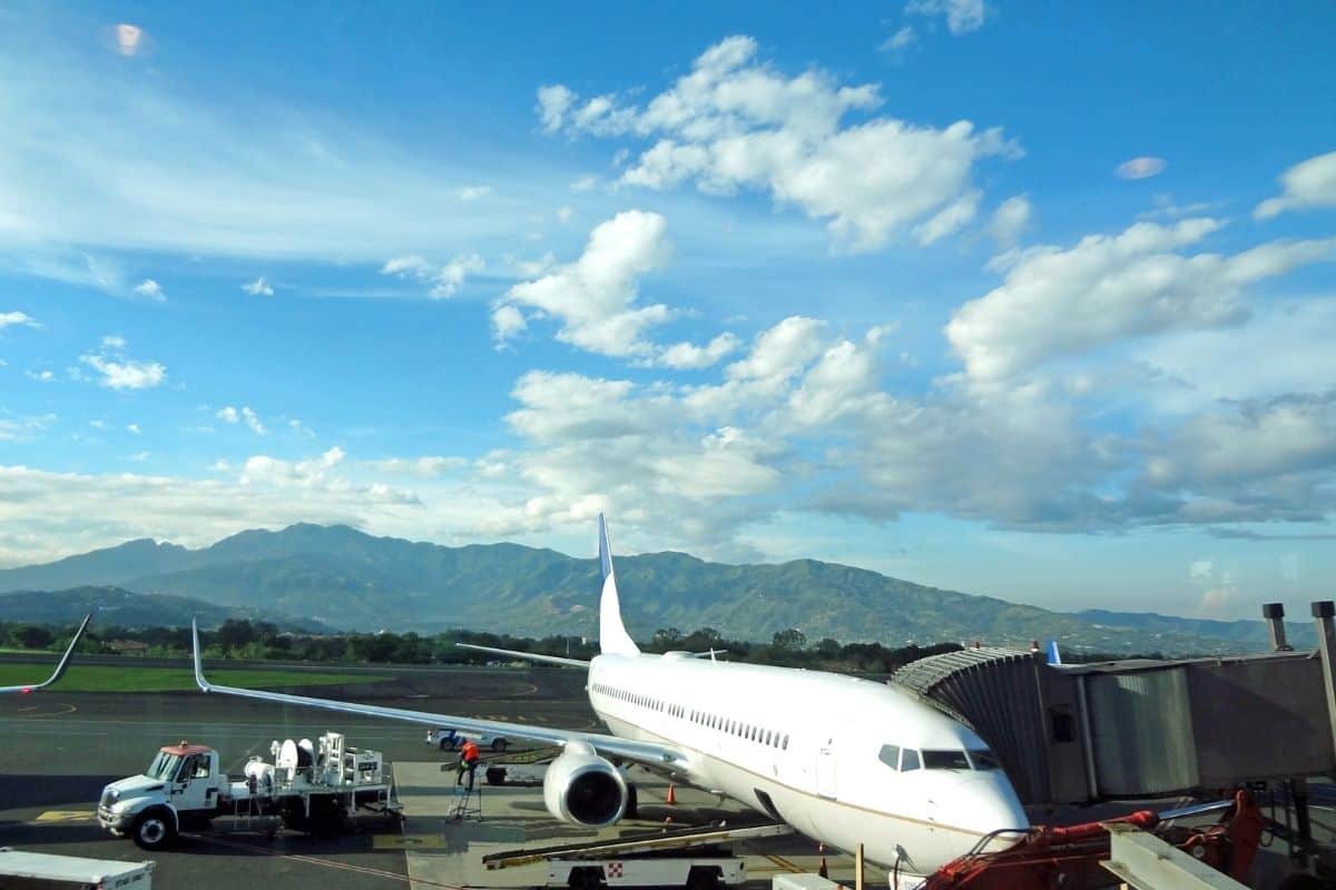 Airplane parked at the gate with mountain views, a common first look at Costa Rica airports