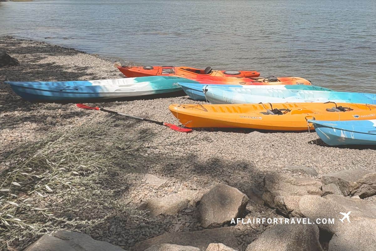 Colorful kayaks along the shore of a lake on a sunny autumn day in New Hampshire