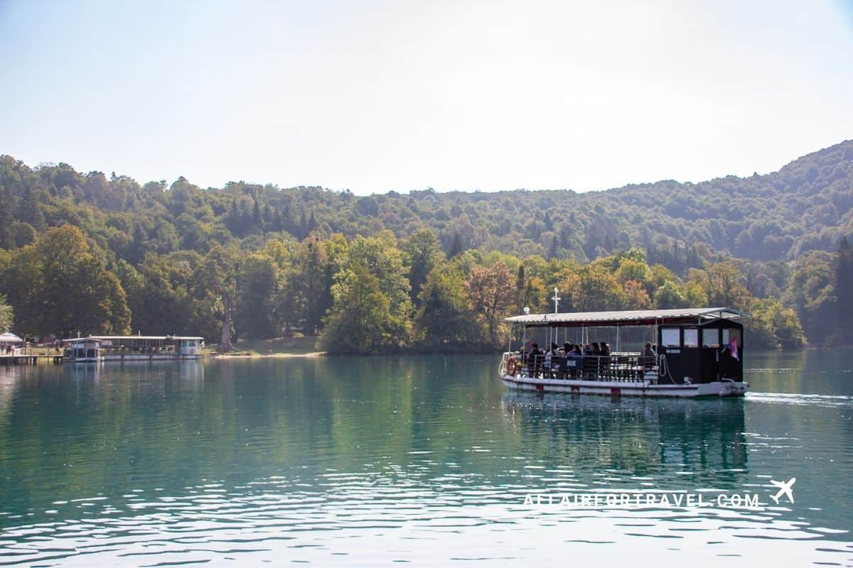 Tour boat crossing a calm lake at Plitvice Lakes National Park, a highlight of visiting Croatia in September