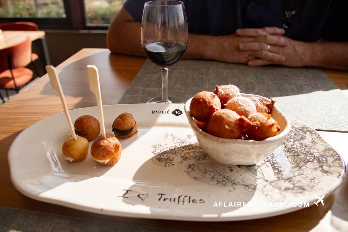 Fritule, a fried-dough dessert, and red wine at a Croatia in September countryside lunch in Istria