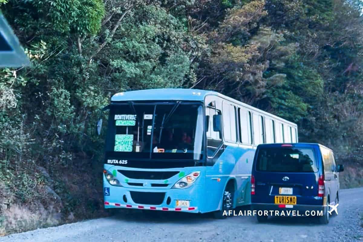 Local bus and van navigating a narrow gravel mountain road in Costa Rica