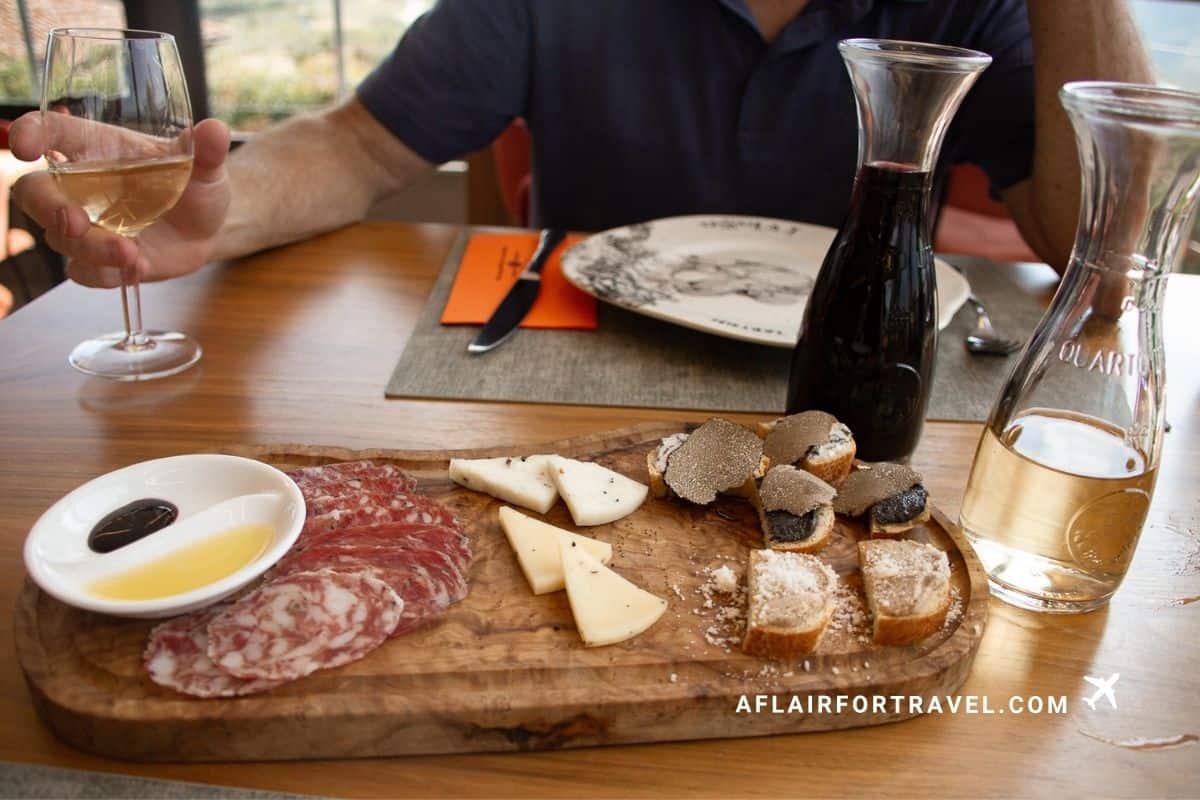 Charcuterie board with cheese, truffle crostini, and wine at an Istrian restaurant