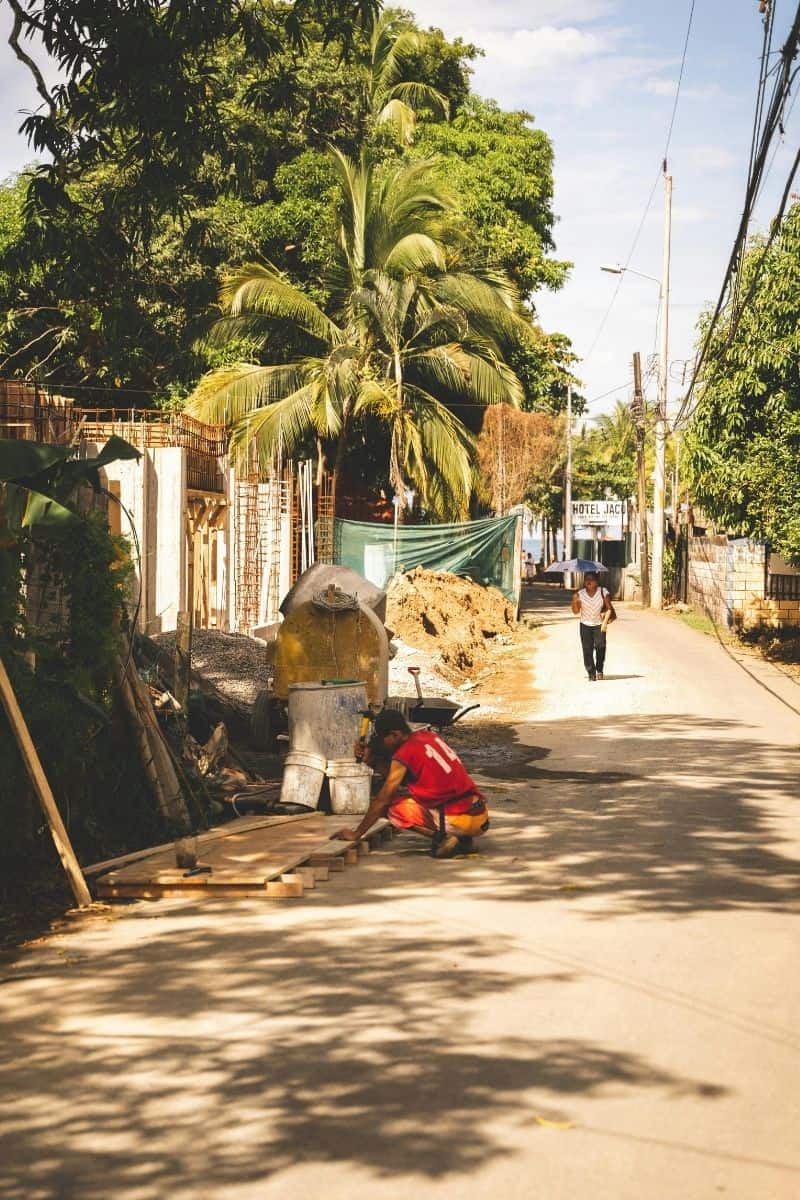 Construction worker along a sandy beach town street in Jacó, Costa Rica