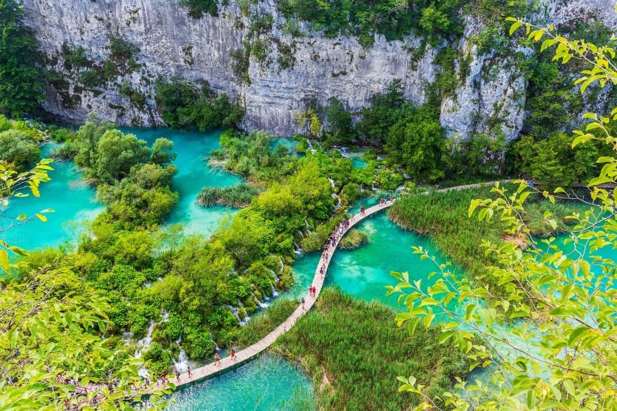 Aerial view of wooden boardwalks winding through the turquoise lakes of Plitvice National Park