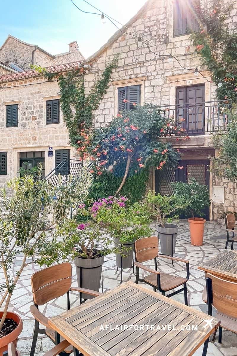 Charming stone courtyard cafe with flowering trees in Stari Grad on the island of Hvar, a lovely stop for Croatia in September