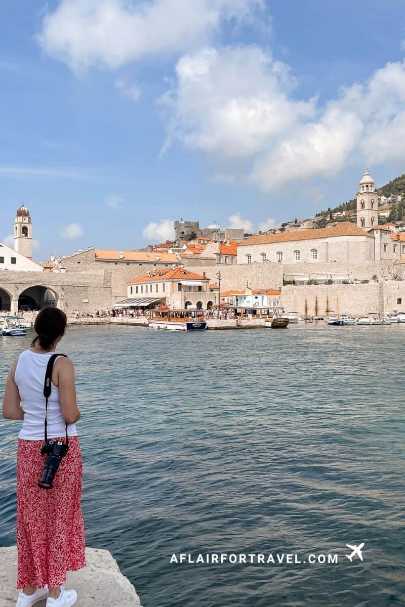 Woman looking out over Dubrovnik's Old Port, a classic view for Croatia in September visitors