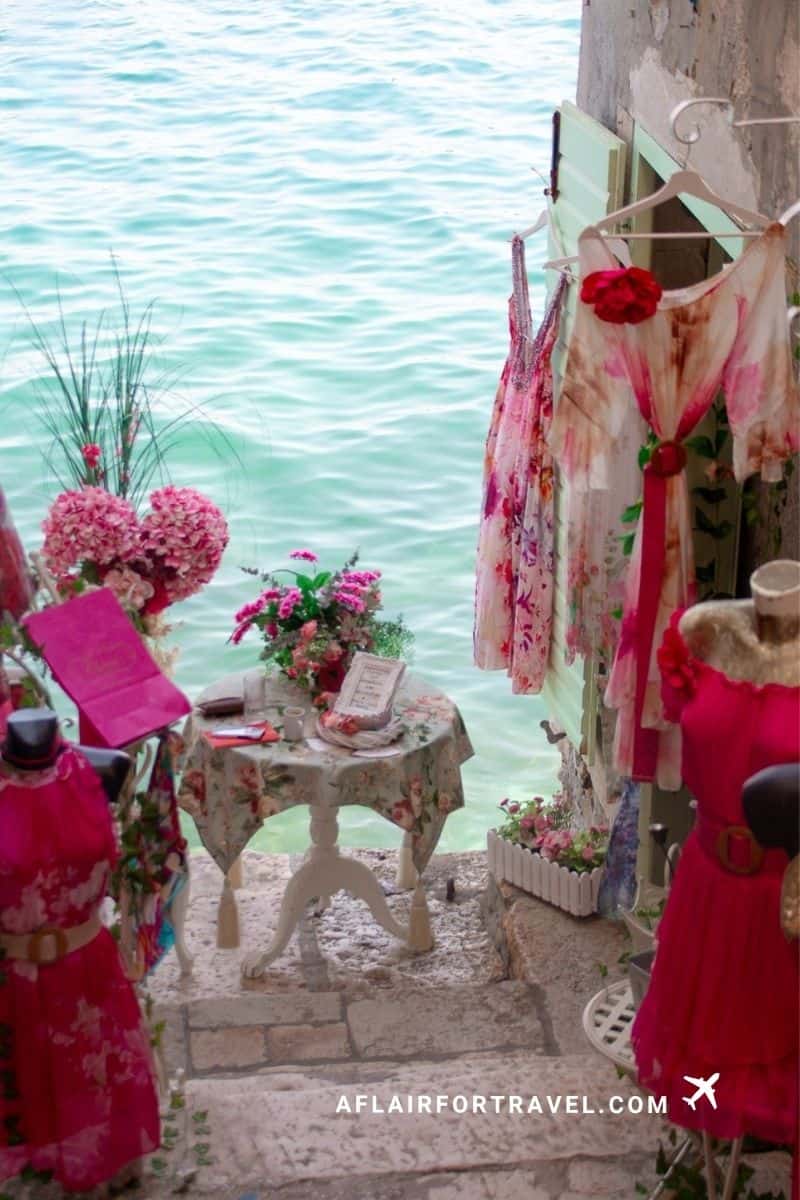 Pink dresses and floral display at a seaside boutique in Rovinj, Croatia