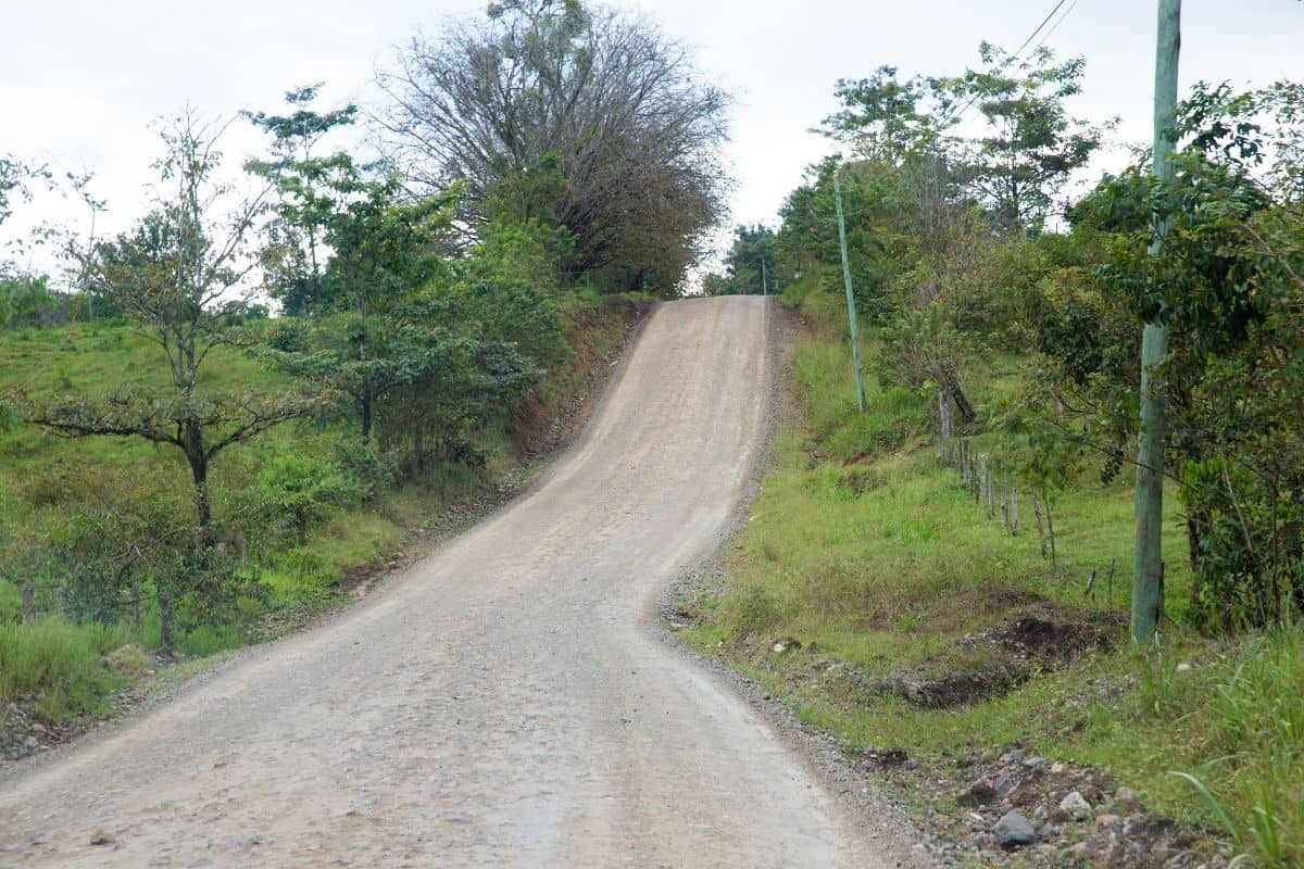 Gravel road climbing a hill through the Costa Rican countryside