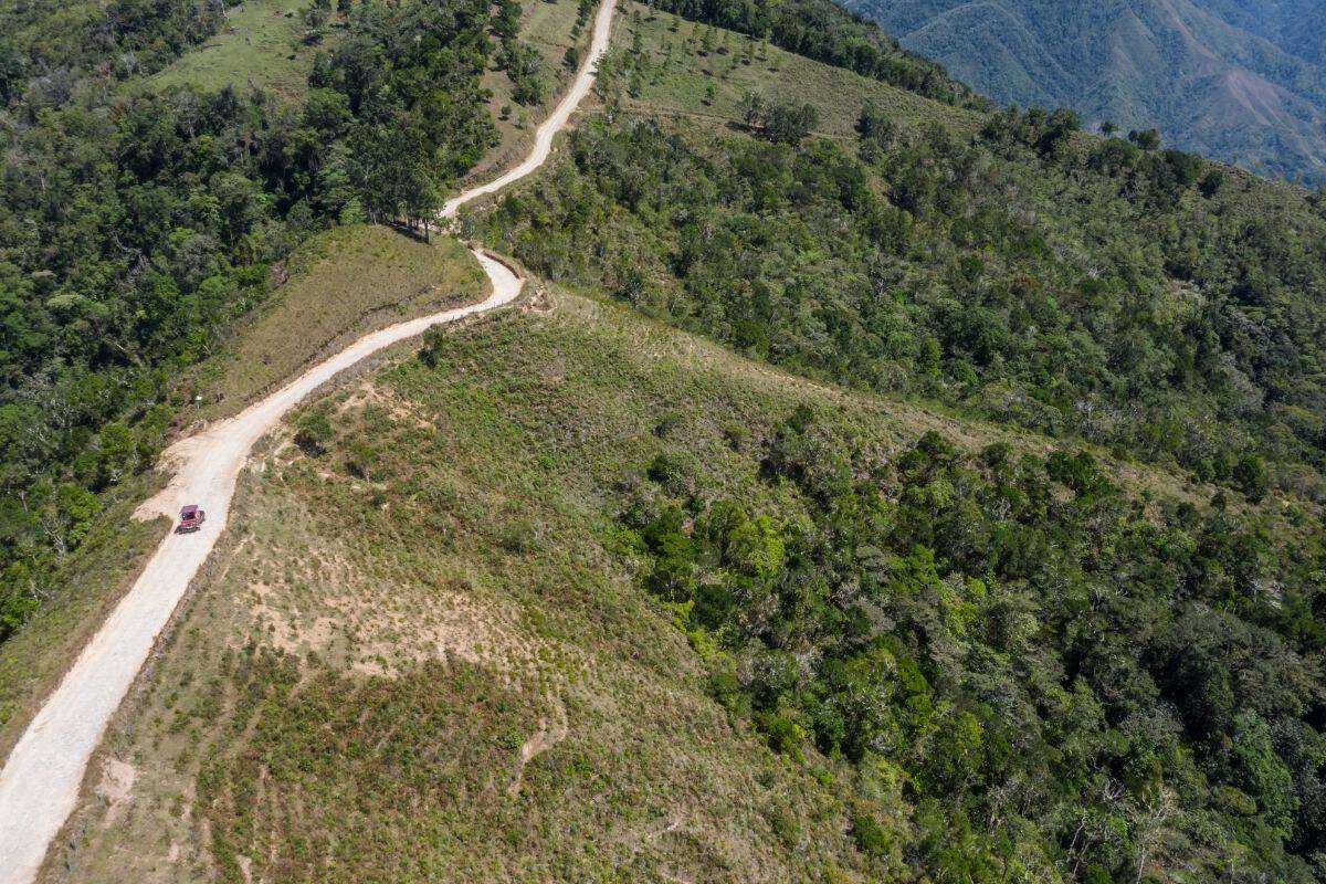 Aerial view of a truck driving along a remote gravel mountain road in Costa Rica