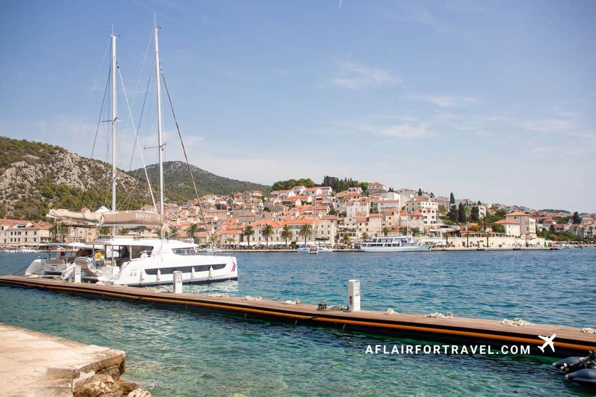 Sailboat docked in Hvar's harbor with the old town in the background