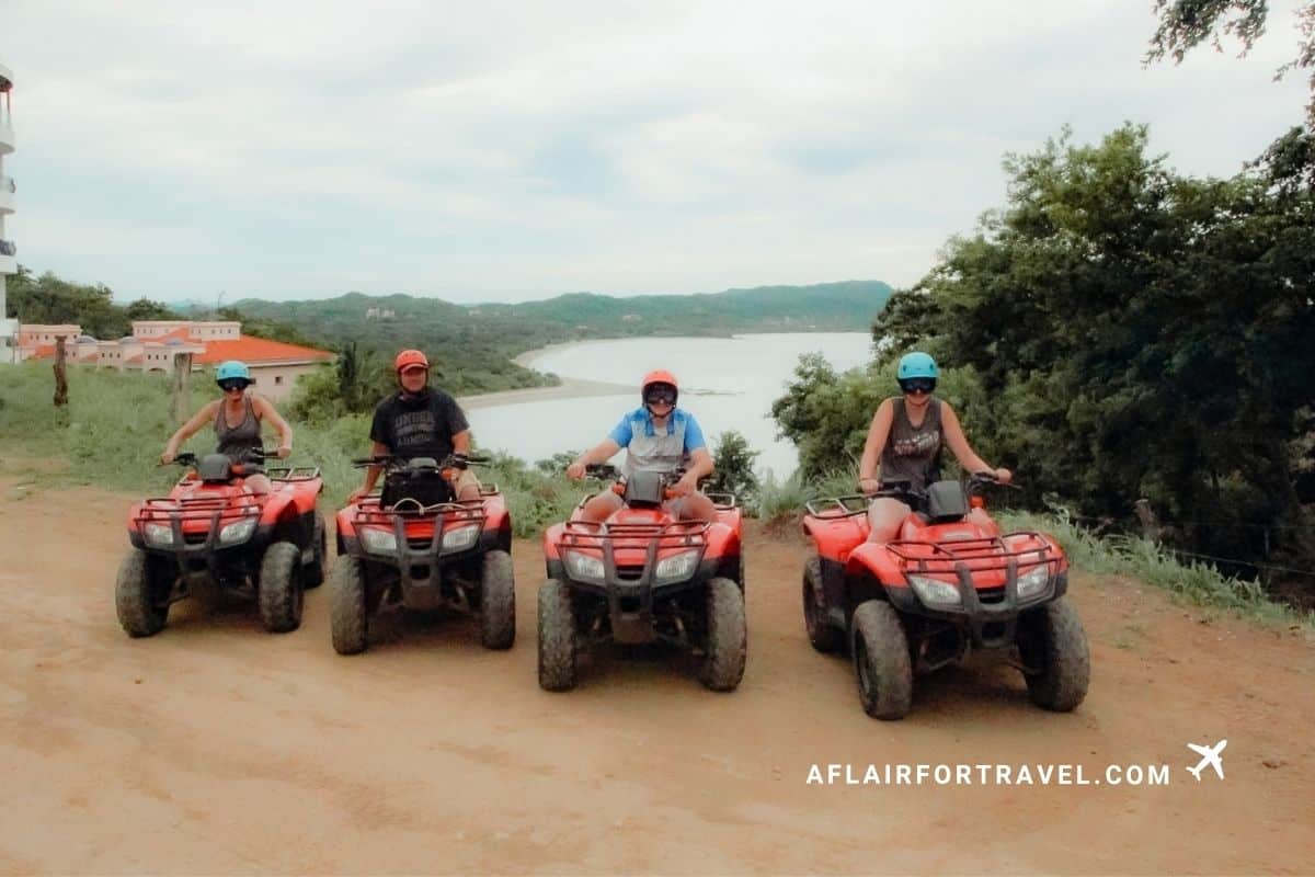 Family of four on ATVs pause for a scenic overlook during a Guanacaste quad tour