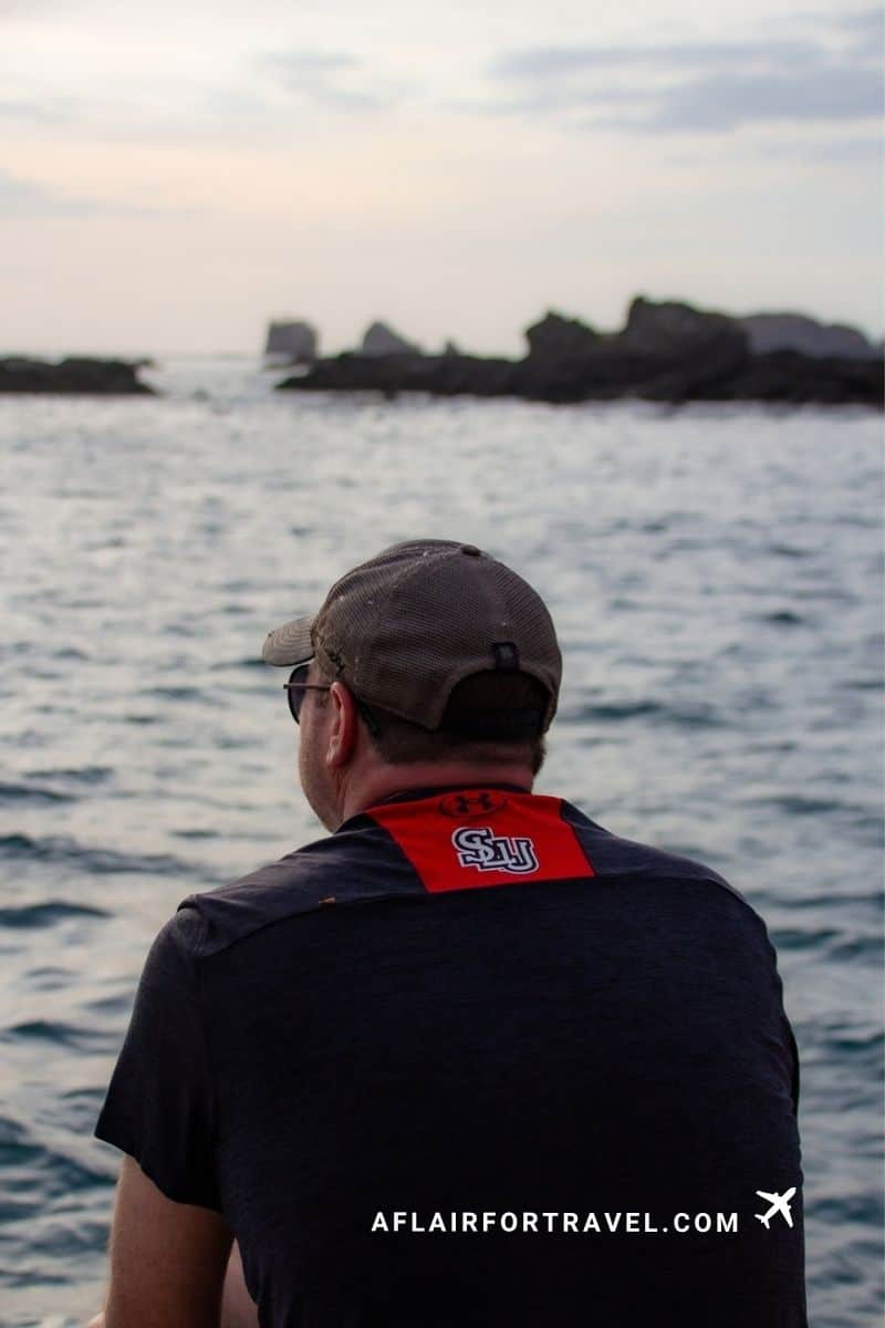 Man looking out over a rocky coastline in Guanacaste