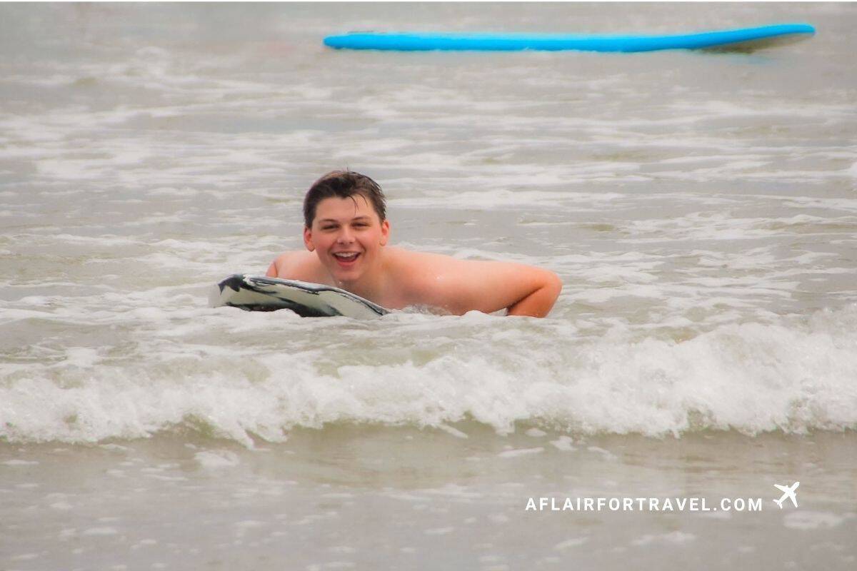 Boy laughing while bodyboarding in Guanacaste, Costa Rica