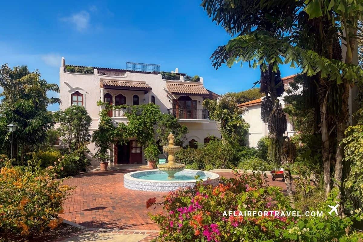 Spanish colonial-style resort building with a courtyard fountain surrounded by bougainvillea, St. Lucia