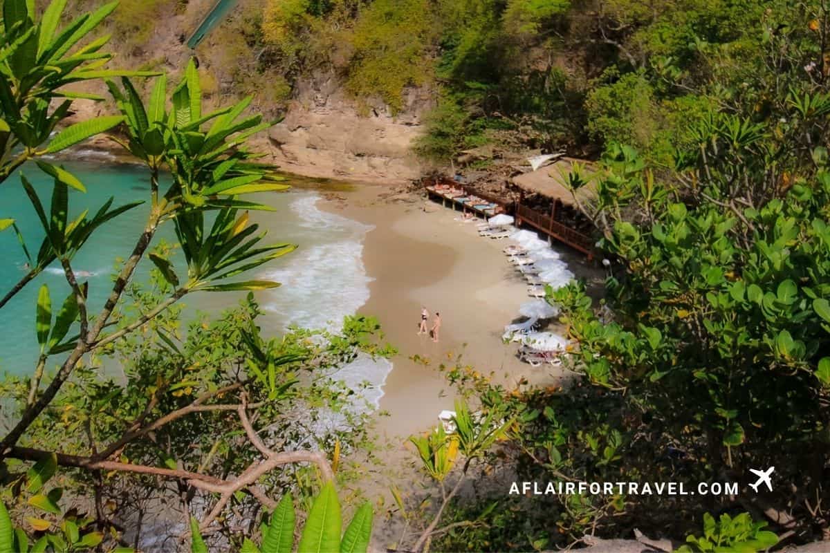 Secluded beach cove with loungers tucked beneath the cliffs at a private resort, St. Lucia