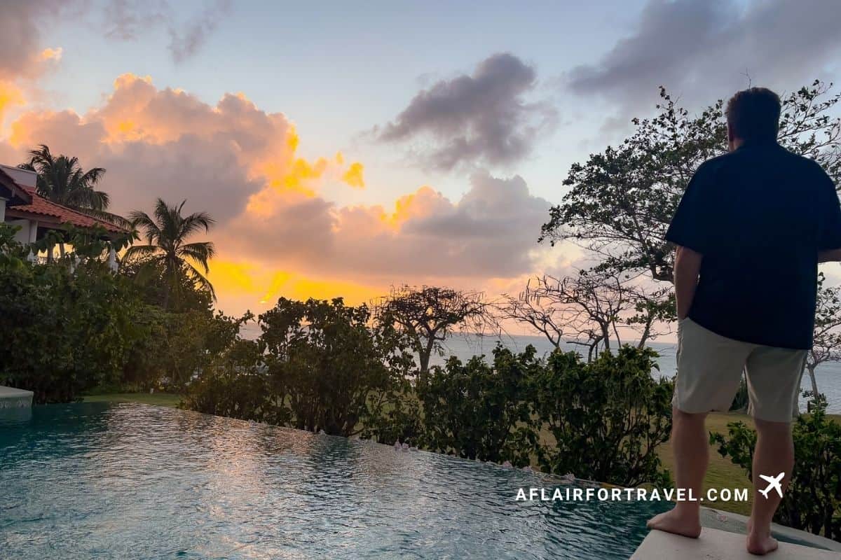 Man watching the sunset over an infinity pool, St. Lucia