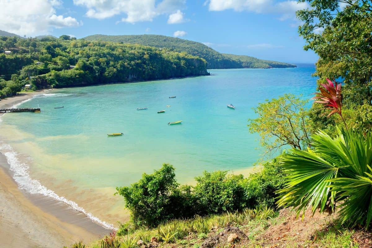 Secluded cove with small fishing boats anchored in clear turquoise water, St. Lucia